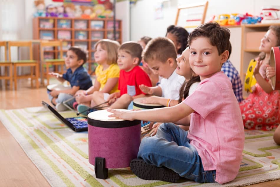 Small group of children on floor learning music